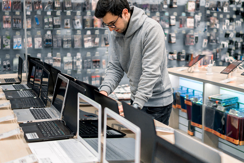 Man browsing laptop computers for purchase