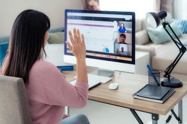 Woman video conferencing with colleagues